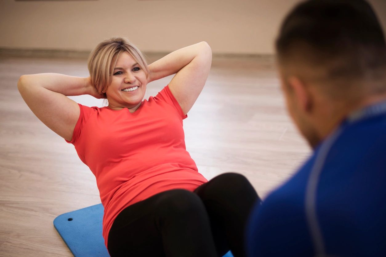 A woman is doing sit ups on the floor